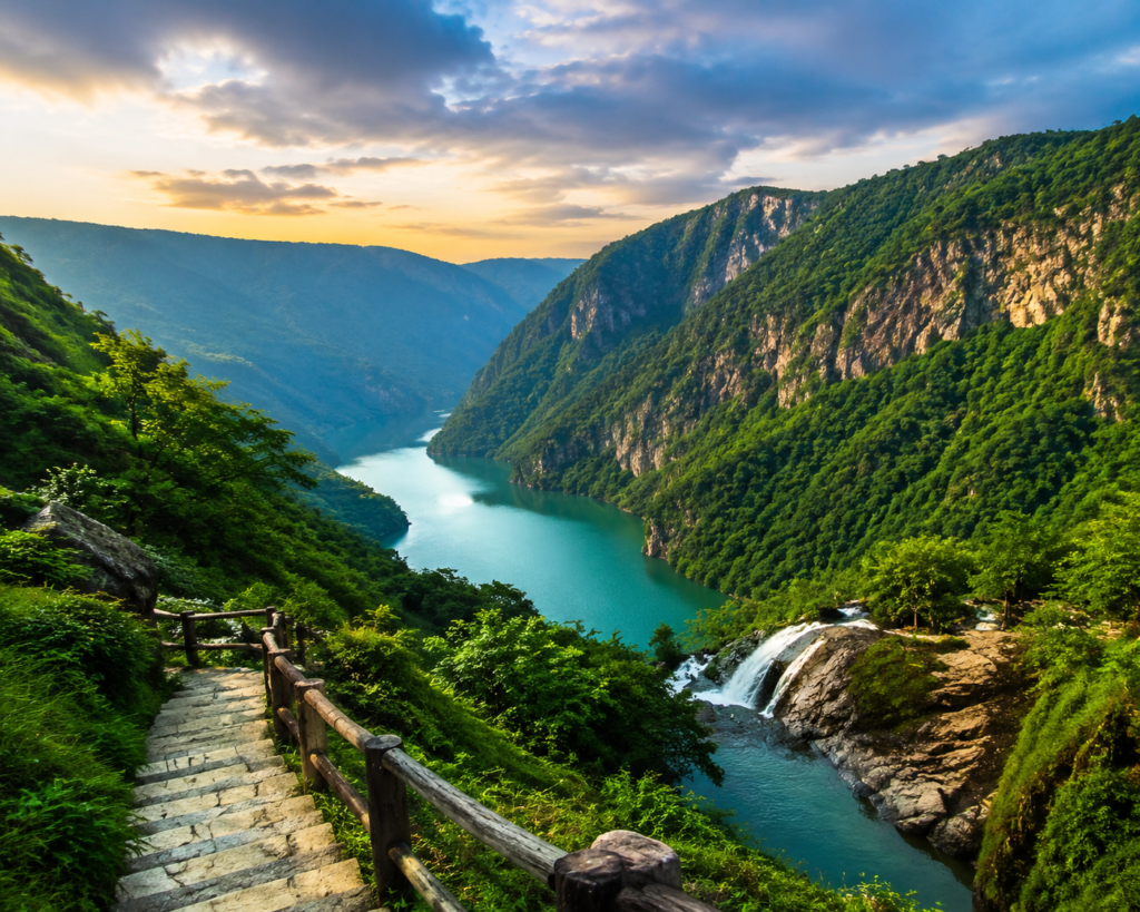 Beautiful Meghalaya landscape with green hills, river valley, and waterfall representing scenic North East India tourism